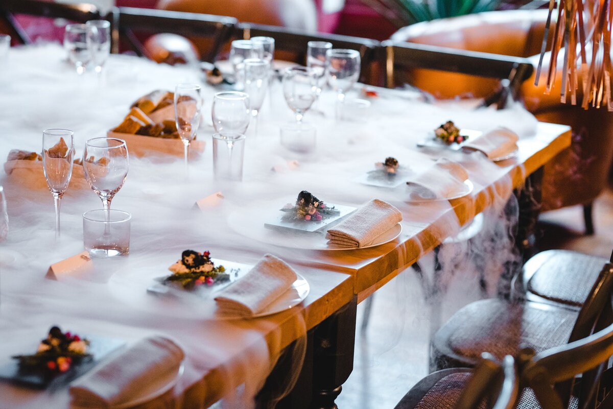 A long dining table laid with glasses, candles and place settings